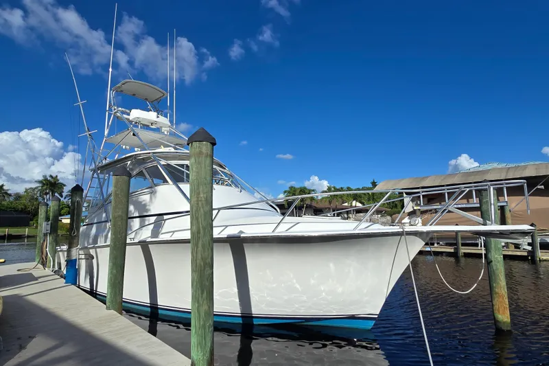 Slide: The Image of 1999 Ocean Yachts 40 Open docked under clear blue sky. - 11
