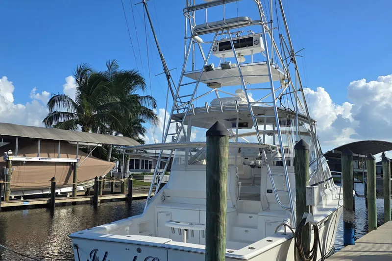 Slide: The Image of 1999 Ocean Yachts 40 Open docked, featuring a tall tower and clear blue sky backdrop. - 16