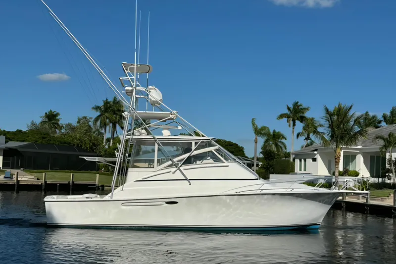 Slide: The Image of 1999 Ocean Yachts 40 Open boat on calm water, surrounded by palm trees and clear blue sky. - 2