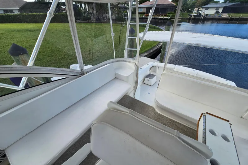 Slide: The Image of 1999 Ocean Yachts 40 Open interior with white seating, docked by a serene waterfront. - 20