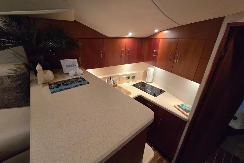 Slide: The Image of Luxurious 1999 Ocean Yachts 40 Open galley with modern amenities and elegant wood cabinetry. - 26