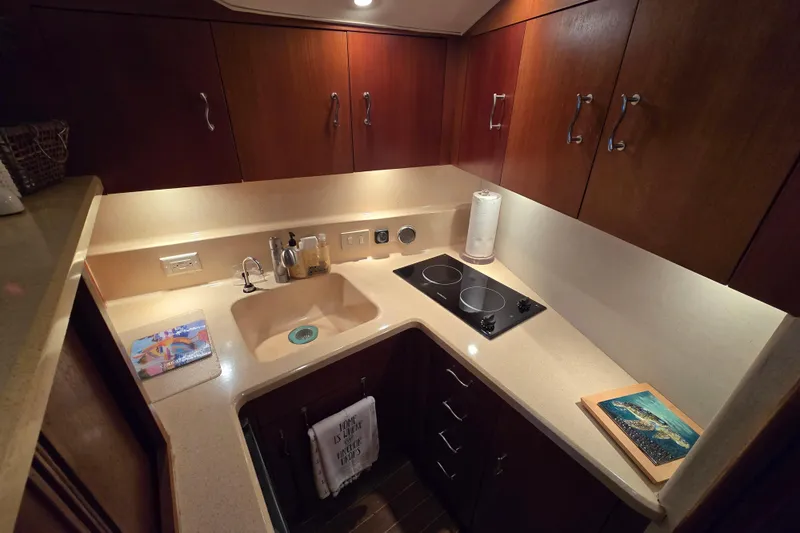 Slide: The Image of Kitchen area of 1999 Ocean Yachts 40 Open with sink, stove, and wooden cabinets. - 27