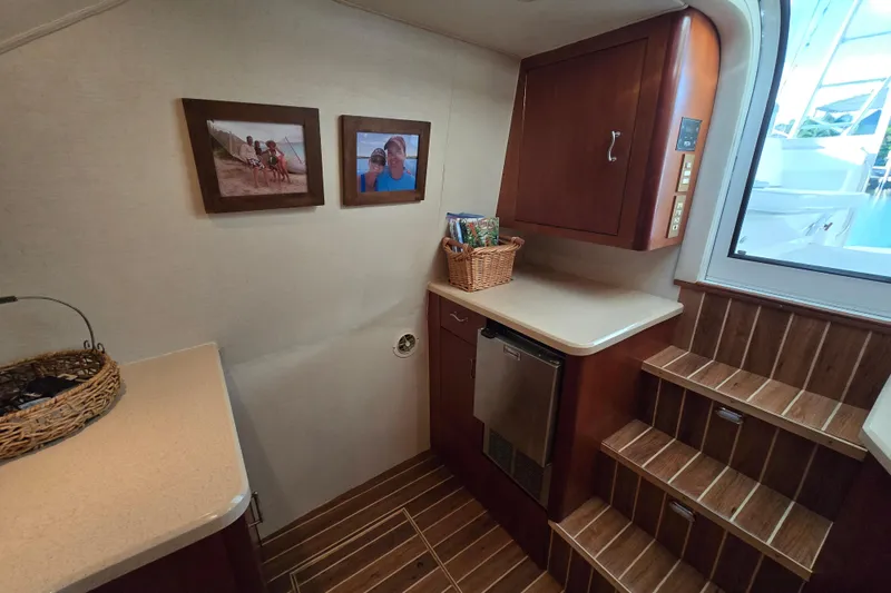 Slide: The Image of Interior of 1999 Ocean Yachts 40 Open, featuring wooden cabinetry and framed photos. - 32