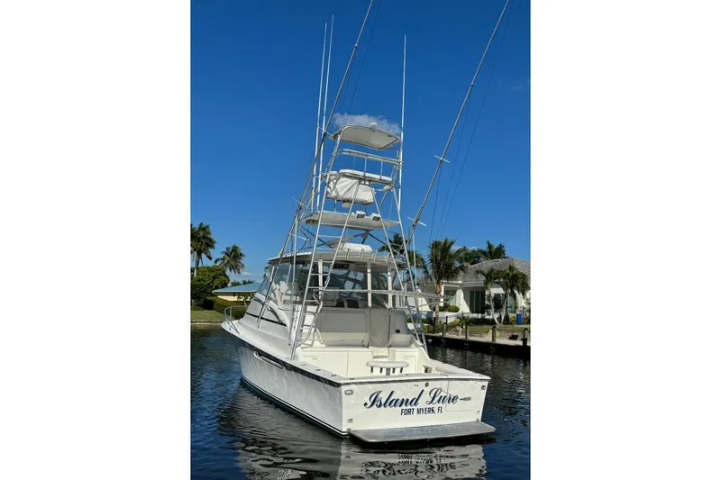 Slide: The Image of 1999 Ocean Yachts 40 Open boat docked, featuring a tall tower and clear blue sky. - 9