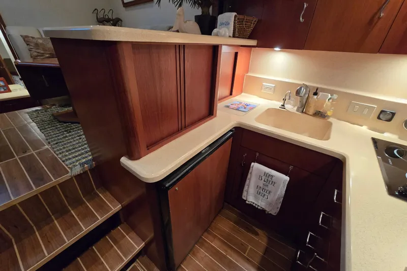 Slide: The Image of 1999 Ocean Yachts 40 Open galley with wood cabinetry, sink, and compact appliances. - 28