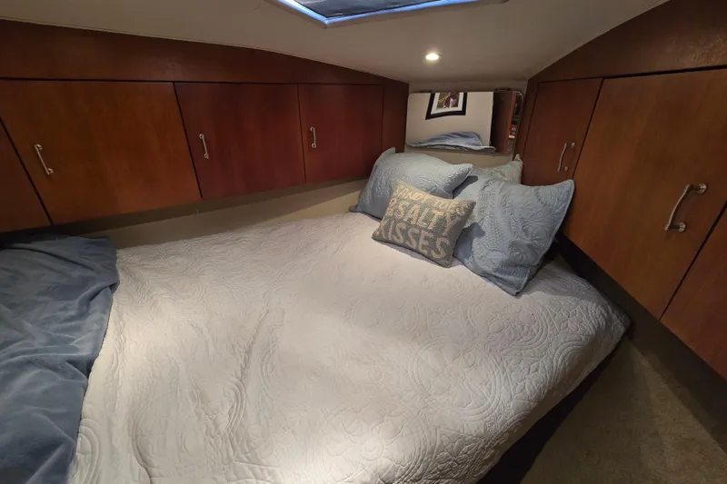 Slide: The Image of Cozy cabin bedroom in 1999 Ocean Yachts 40 Open, featuring wood cabinets and nautical decor. - 30