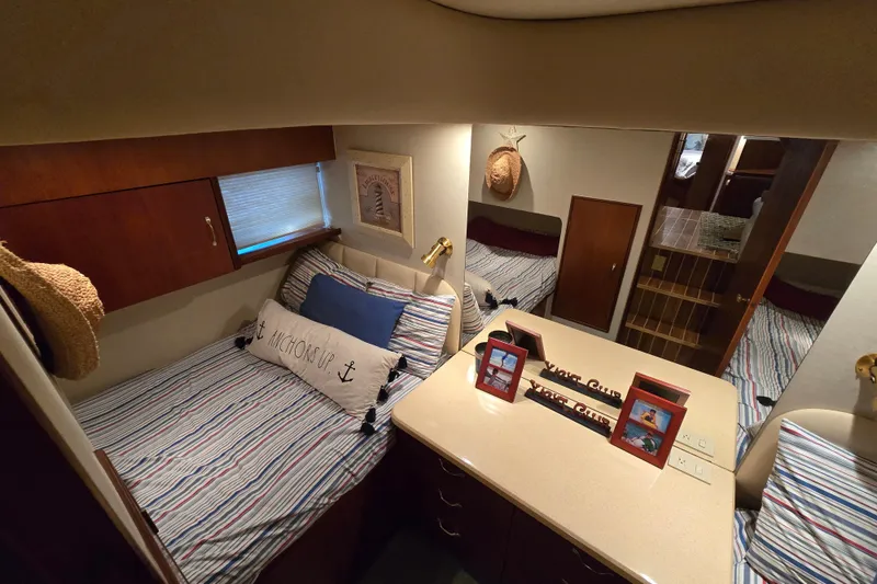 Slide: The Image of Cozy cabin interior of 1999 Ocean Yachts 40 Open, featuring striped bedding and nautical decor. - 33
