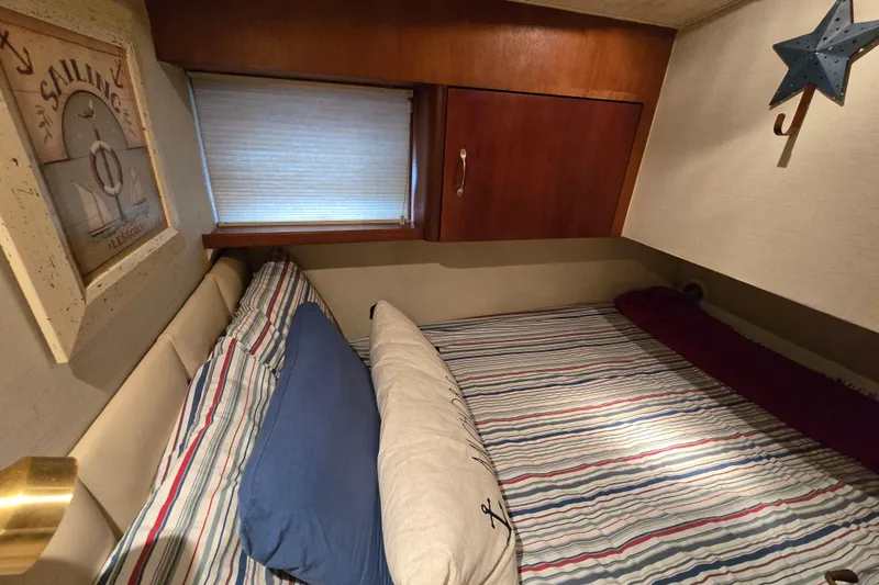 Slide: The Image of Cozy cabin interior of 1999 Ocean Yachts 40 Open, featuring striped bedding and nautical decor. - 34