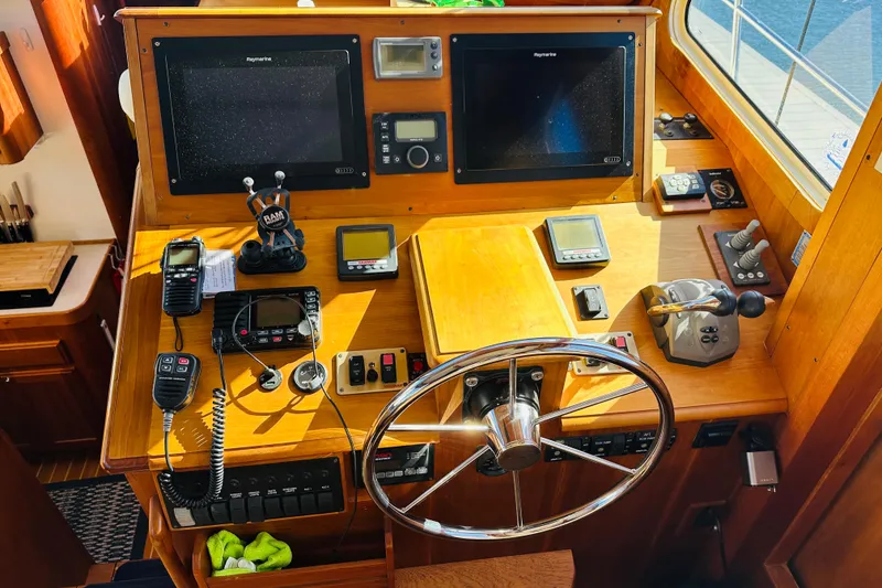 Slide: The Image of 2006 Sabre 42 Fly Bridge helm with navigation equipment and wooden dashboard. - 19