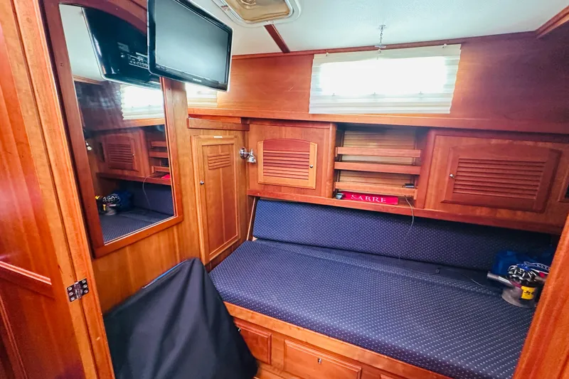 Slide: The Image of 2006 Sabre 42 Fly Bridge cabin interior with wood paneling and blue seating. - 23