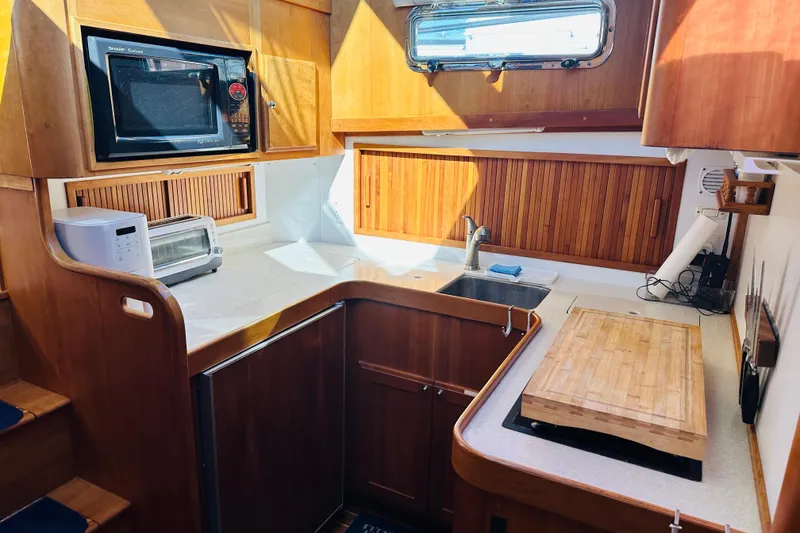 Slide: The Image of Cozy kitchen in 2006 Sabre 42 Fly Bridge yacht with wooden cabinetry and modern appliances. - 25