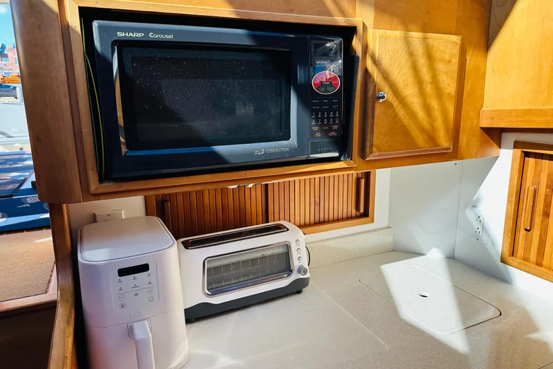 Slide: The Image of 2006 Sabre 42 Fly Bridge kitchen with microwave, toaster oven, and air fryer. - 27