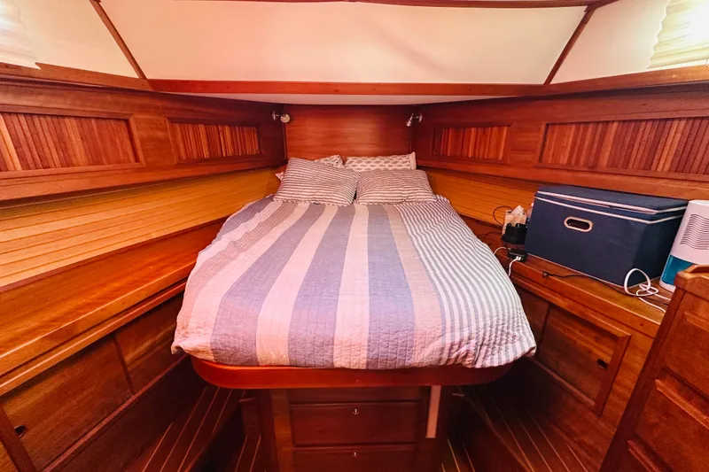 Slide: The Image of Cozy cabin interior of 2006 Sabre 42 Fly Bridge with wooden finish and striped bedding. - 28