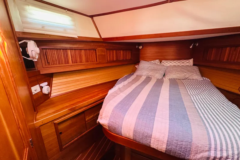 Slide: The Image of Cozy cabin interior of 2006 Sabre 42 Fly Bridge with striped bedding and wooden accents. - 29