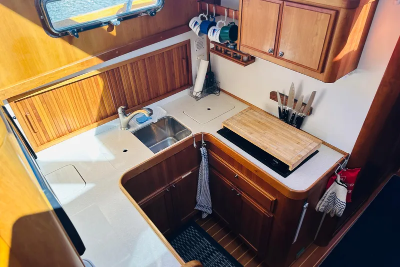 Slide: The Image of 2006 Sabre 42 Fly Bridge yacht kitchen with wooden cabinets and countertop. - 3