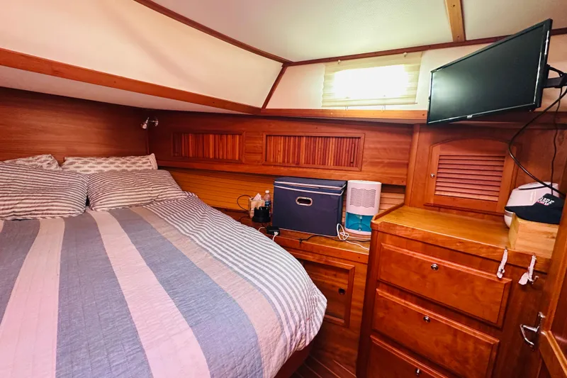 Slide: The Image of Cozy cabin interior of 2006 Sabre 42 Fly Bridge with bed, TV, and wooden storage. - 30