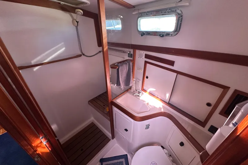 Slide: The Image of 2006 Sabre 42 Fly Bridge bathroom with shower, sink, and wooden accents. - 31
