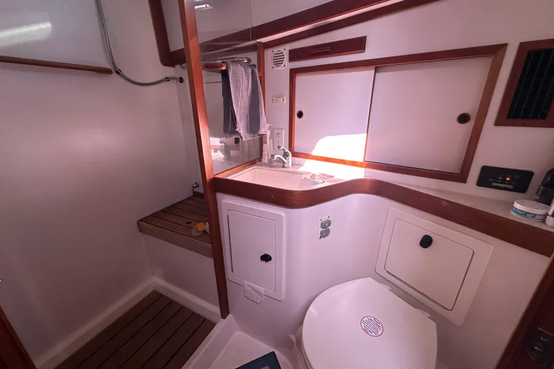 Slide: The Image of 2006 Sabre 42 Fly Bridge yacht bathroom with sink, toilet, and wooden accents. - 32
