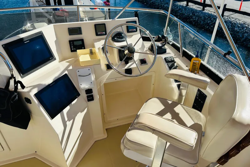 Slide: The Image of 2006 Sabre 42 Fly Bridge helm with steering wheel, navigation screens, and captain's chair. - 50