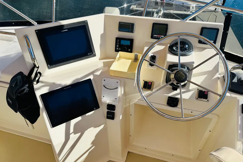 Slide: The Image of Helm of 2006 Sabre 42 Fly Bridge with navigation screens and steering wheel. - 52