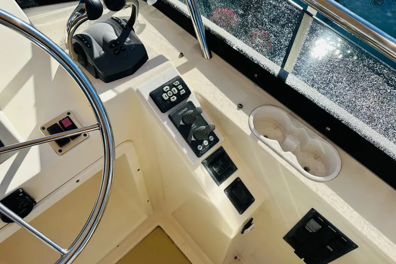 Slide: The Image of 2006 Sabre 42 Fly Bridge helm with controls, steering wheel, and cup holders. - 54