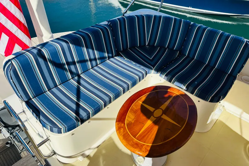 Slide: The Image of Blue striped seating and wooden table on 2006 Sabre 42 Fly Bridge yacht deck. - 56
