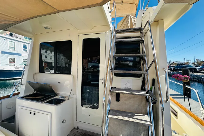 Slide: The Image of 2006 Sabre 42 Fly Bridge yacht with outdoor grill and staircase to upper deck. - 58