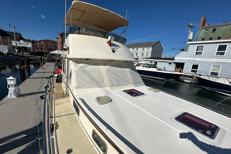 Slide: The Image of 2006 Sabre 42 Fly Bridge yacht docked at marina under clear blue sky. - 65