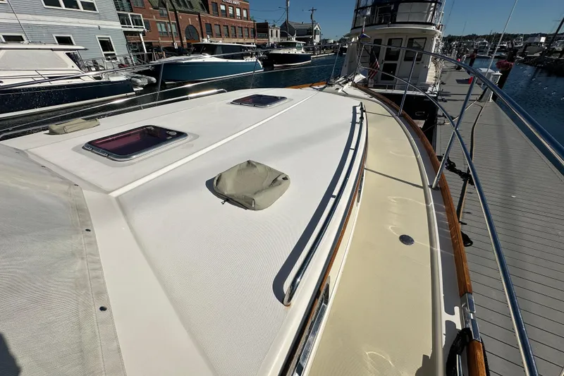 Slide: The Image of 2006 Sabre 42 Fly Bridge yacht docked at marina, showcasing deck and hatch details. - 66