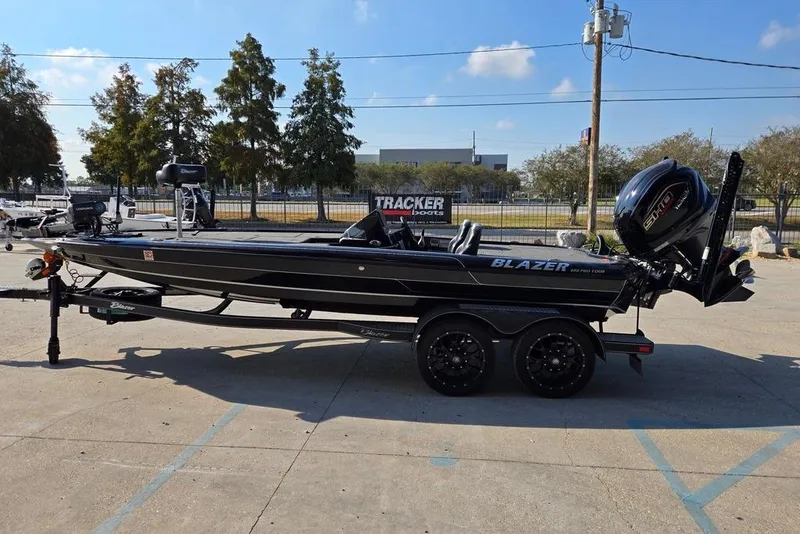 Slide: The Image of 2024 Blazer 650 Pro Tour boat on trailer, parked outdoors, side view. - 6