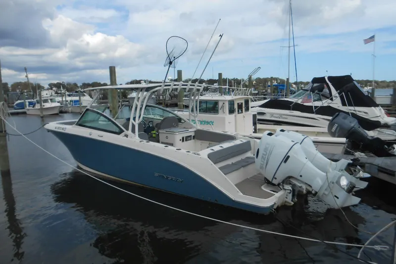 The Image of 2022 Stingray 269 DC boat docked at marina with twin Suzuki outboard engines. - 0