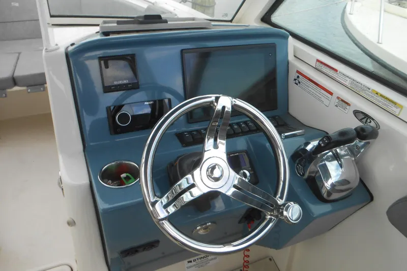 Slide: The Image of 2022 Stingray 269 DC boat dashboard with steering wheel and control panel. - 10