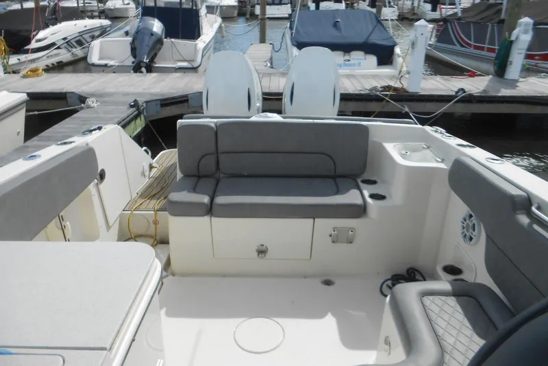 Slide: The Image of 2022 Stingray 269 DC boat interior with gray seating at a marina dock. - 11