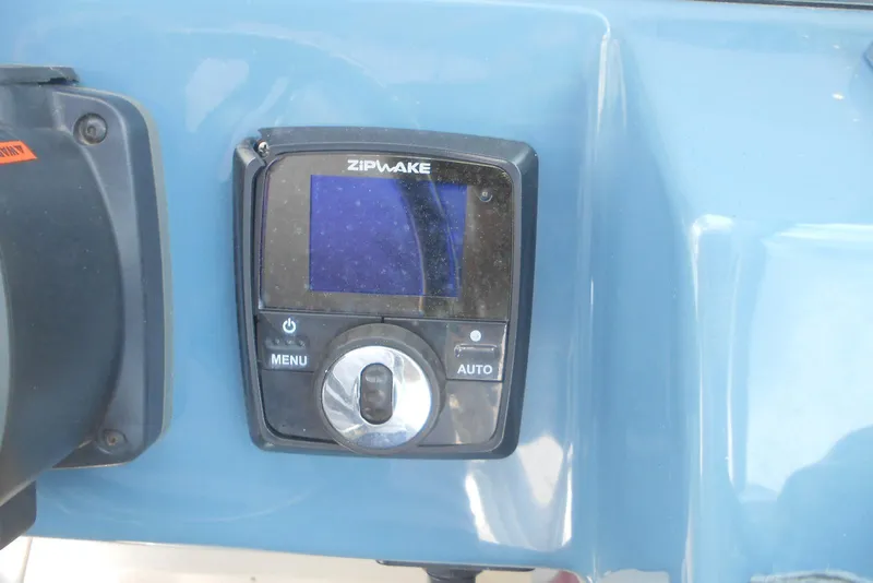 Slide: The Image of Control panel of a 2022 Stingray 269 DC boat featuring a Zipwake display. - 12