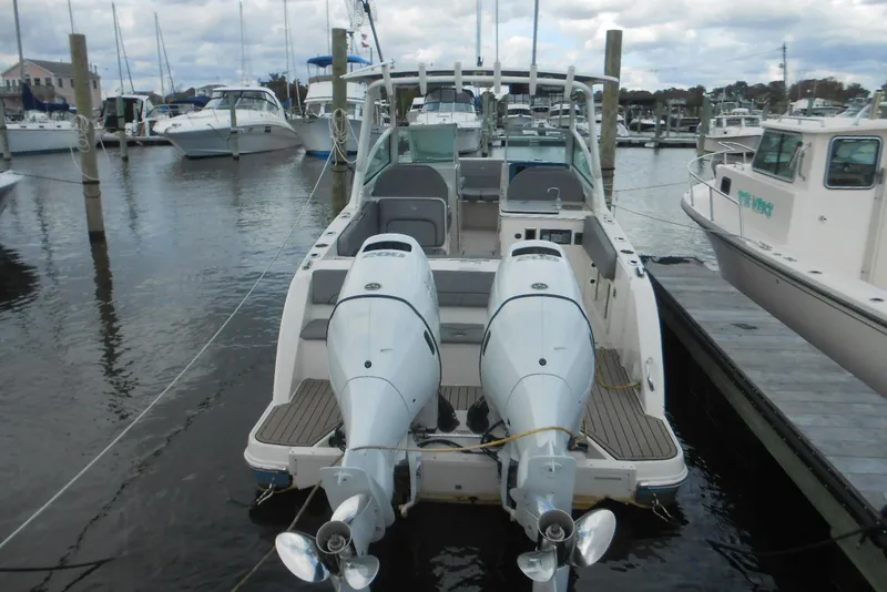Slide: The Image of 2022 Stingray 269 DC boat docked with dual outboard motors in a marina. - 15