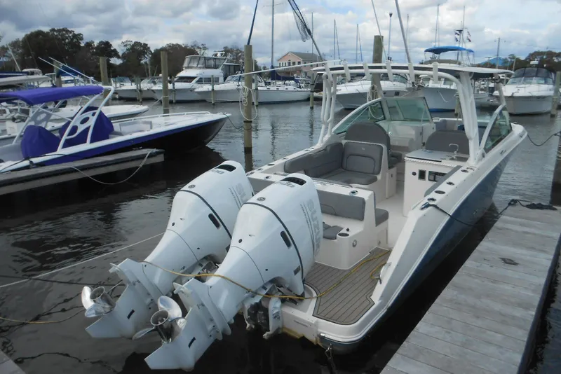 Slide: The Image of 2022 Stingray 269 DC boat docked with dual outboard engines in a marina. - 3