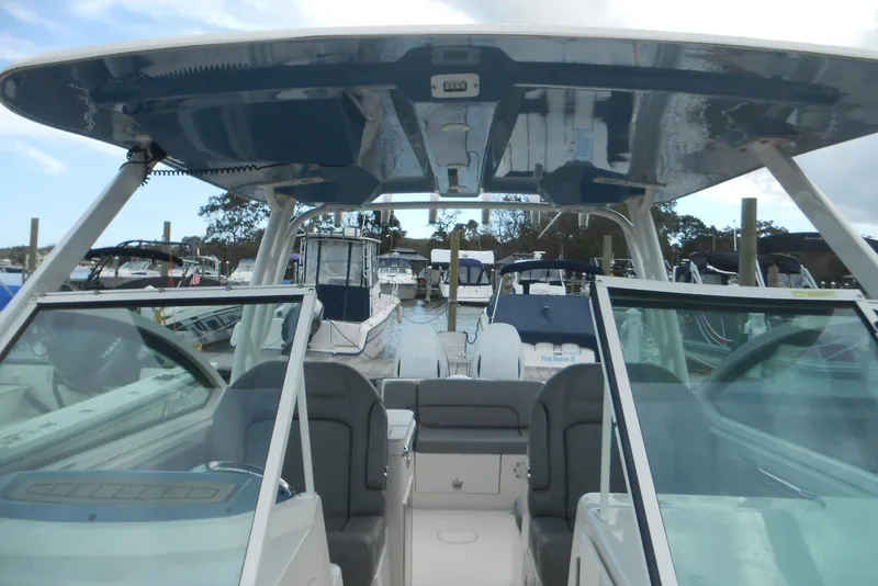 Slide: The Image of 2022 Stingray 269 DC boat interior at marina, showcasing seating and helm. - 7