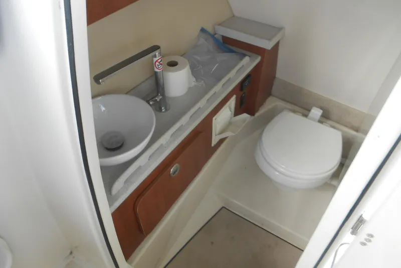 Slide: The Image of 2022 Stingray 269 DC boat bathroom with sink, toilet, and storage cabinet. - 8