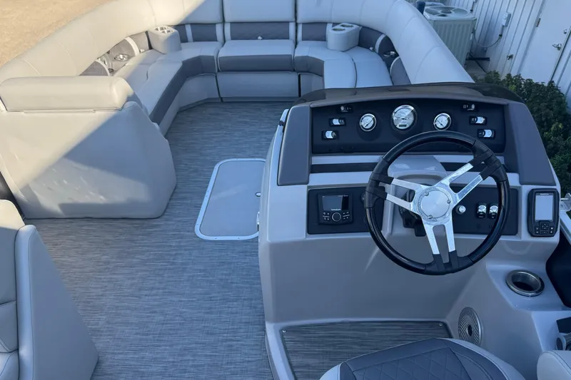 Slide: The Image of 2021 Bennington L 25 Swingback boat interior with steering console and plush seating. - 13