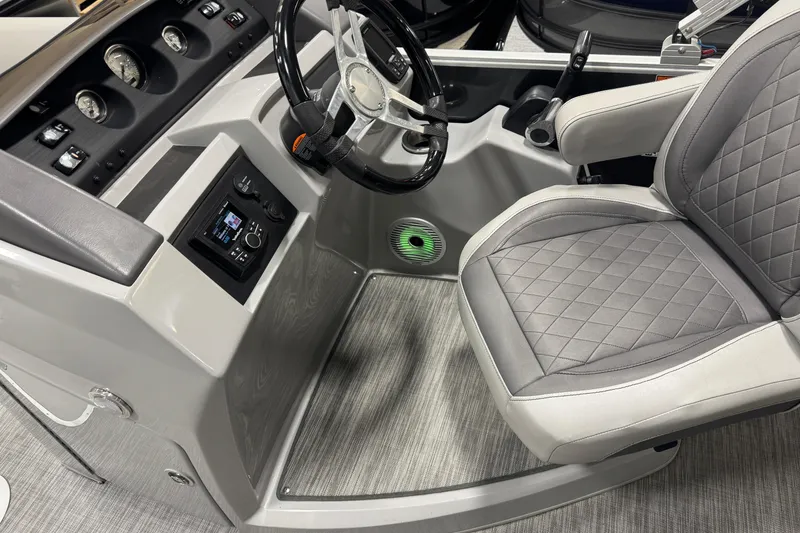 Slide: The Image of 2021 Bennington L 25 Swingback boat interior with steering wheel and cushioned seat. - 16