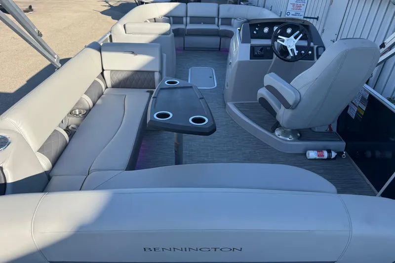 Slide: The Image of 2021 Bennington L 25 Swingback pontoon boat interior with plush seating and steering console. - 20