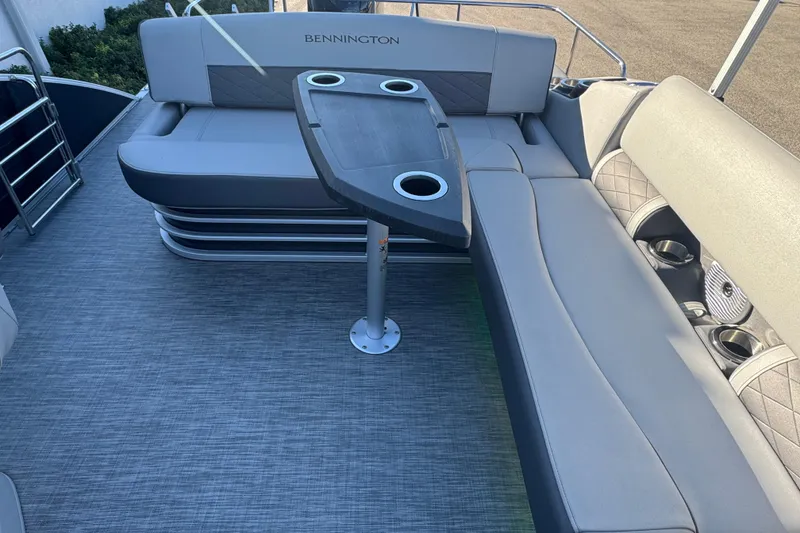 Slide: The Image of 2021 Bennington L 25 Swingback interior with seating and table, featuring cup holders. - 24