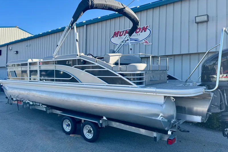 Slide: The Image of 2021 Bennington L 25 Swingback pontoon boat on trailer outside dealership. - 3