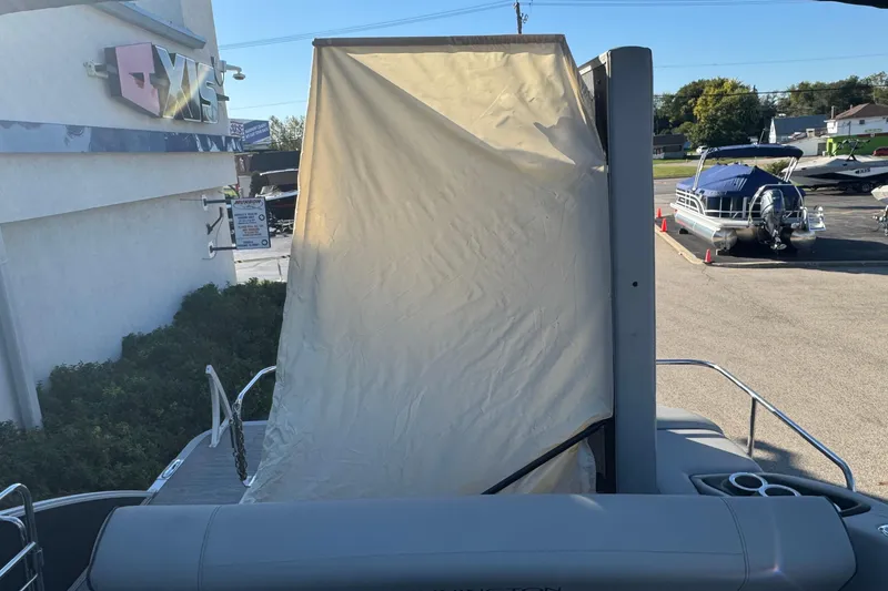 Slide: The Image of 2021 Bennington L 25 Swingback pontoon boat with canopy, parked near dealership. - 30