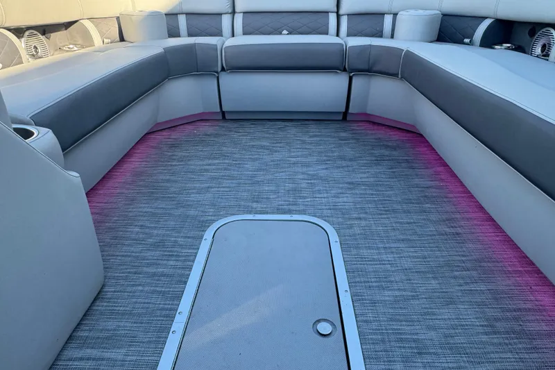 Slide: The Image of 2021 Bennington L 25 Swingback interior with gray seating and pink LED floor lighting. - 6