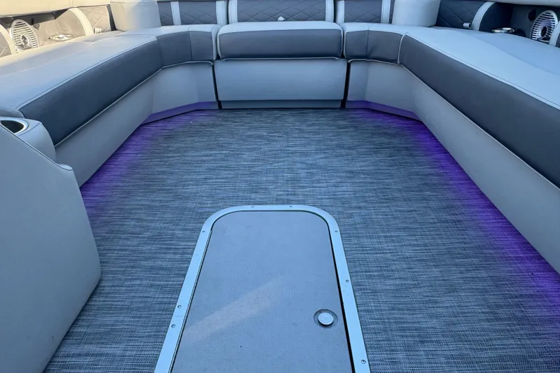 Slide: The Image of 2021 Bennington L 25 Swingback interior with gray seating and purple LED lighting. - 8