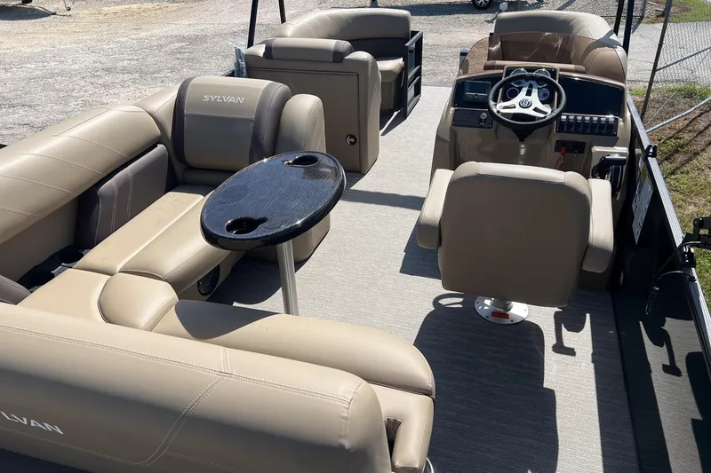 Slide: The Image of 2026 Sylvan Mirage 822 CLZ pontoon boat interior with beige seating and steering console. - 10
