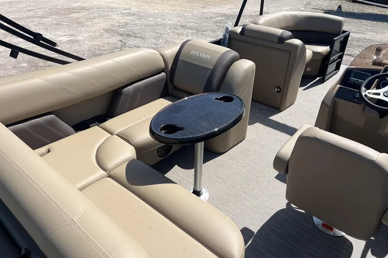 Slide: The Image of 2026 Sylvan Mirage 822 CLZ pontoon boat interior with beige seating and table. - 11