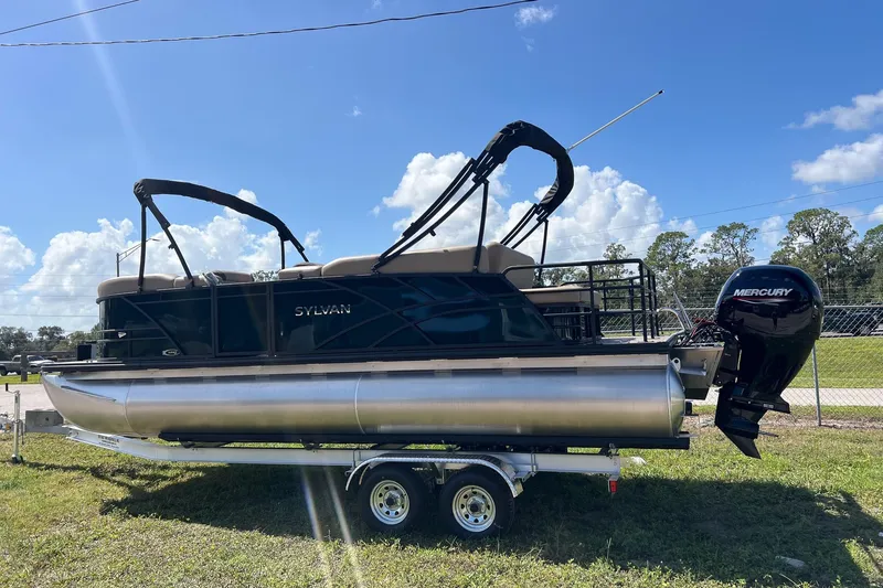 Slide: The Image of 2026 Sylvan Mirage 822 CLZ pontoon boat on trailer, featuring Mercury outboard motor. - 2