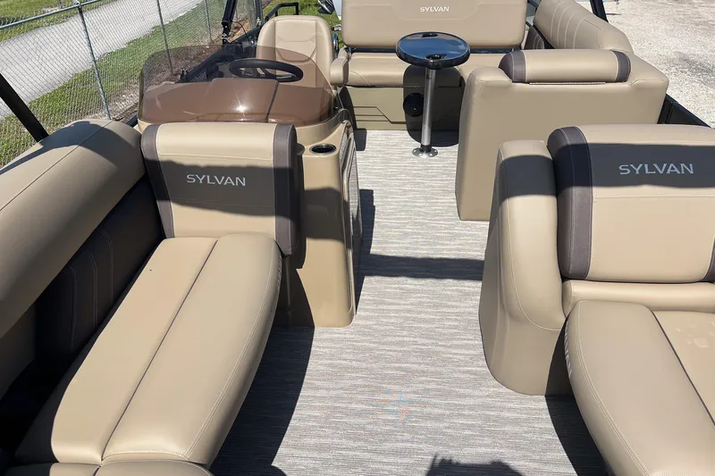 Slide: The Image of 2026 Sylvan Mirage 822 CLZ pontoon boat interior with beige seating and table. - 20